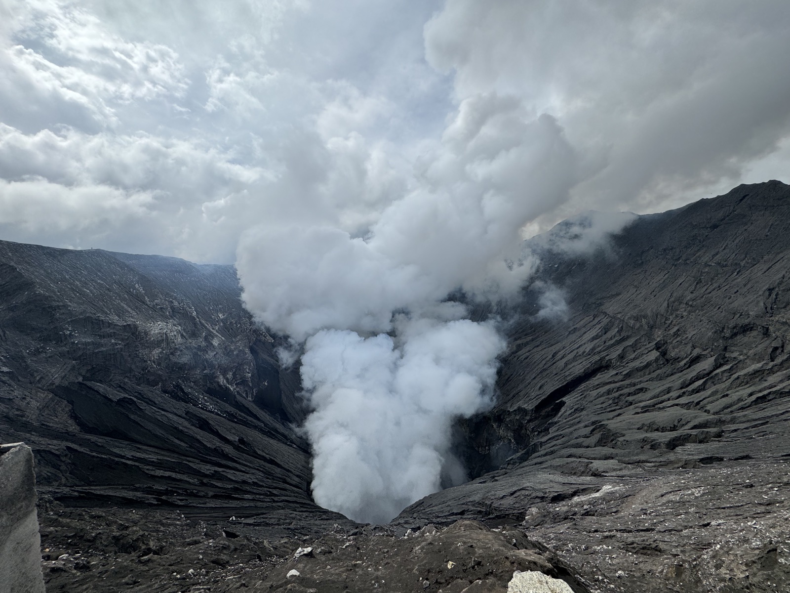 Volcanic crater landscape with steam rising from the mountain